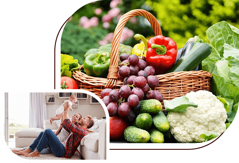 A basket of fruit and vegetables with two people sitting on the couch.