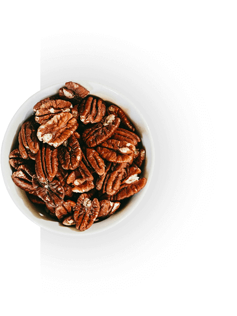 A bowl of pecans on top of a table.