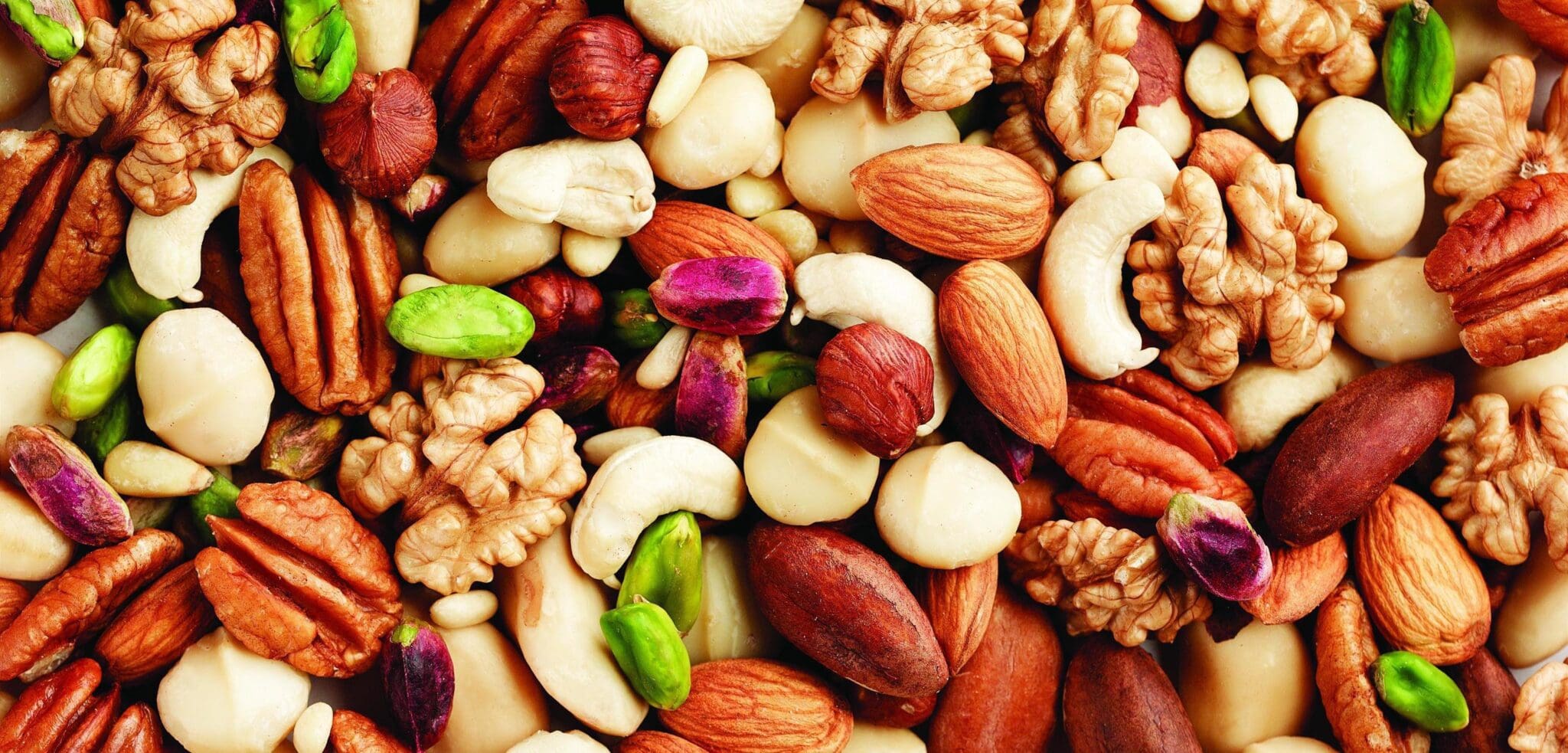 A close up of nuts including peanuts, almonds and pistachios