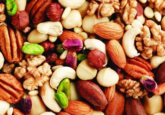 A close up of nuts including peanuts, almonds and pistachios